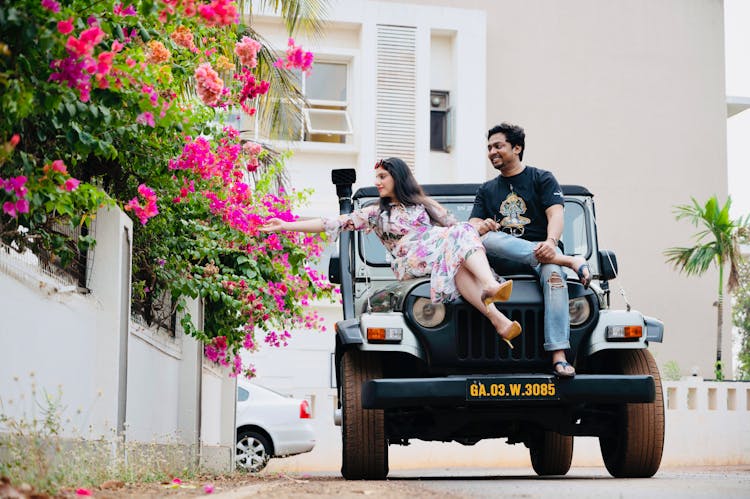 A Couple Sitting On Black Jeep