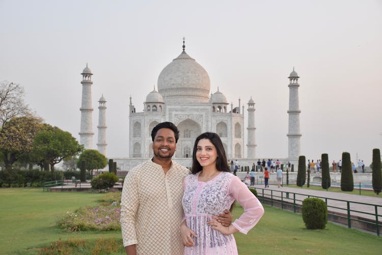 A Couple Posing In The Garden Of Taj Mahal In India