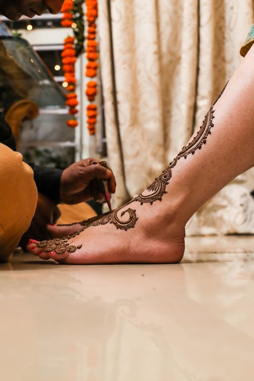 Free A Person Getting a Henna Tattoo on Her Feet Stock Photo