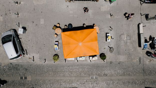 Top view of a vibrant street cafe with orange canopy in Napoli, Italy.