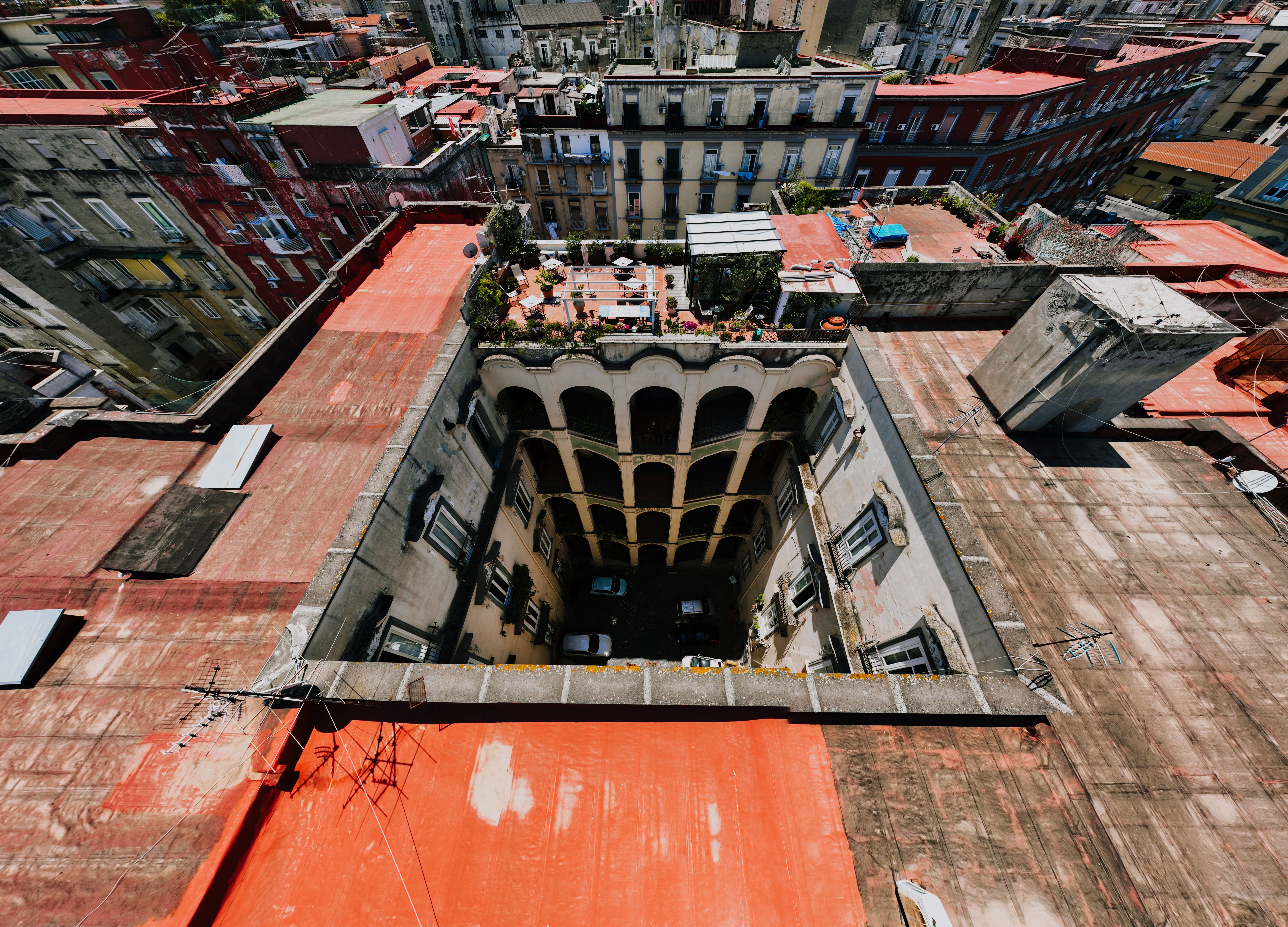 Aerial shot of a rooftop courtyard in Naples, Italy showcasing vibrant architecture.
