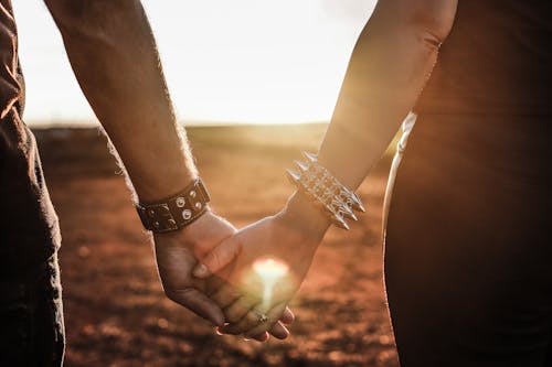 Free People Standing in Front of Sunlight While Holding Hands Stock Photo