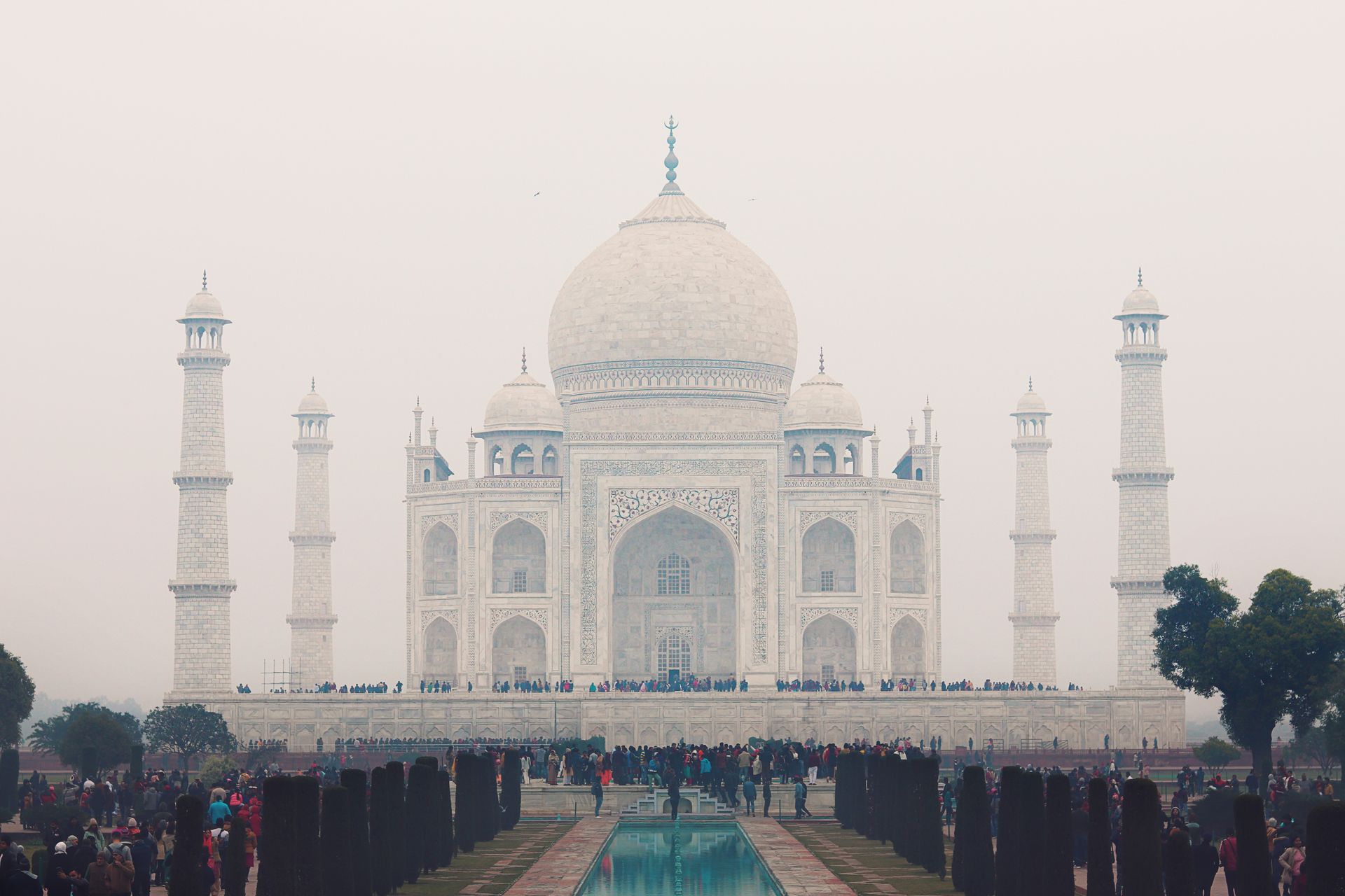 Iconic Taj Mahal in Agra, India amidst a crowd, showcasing its stunning architecture.