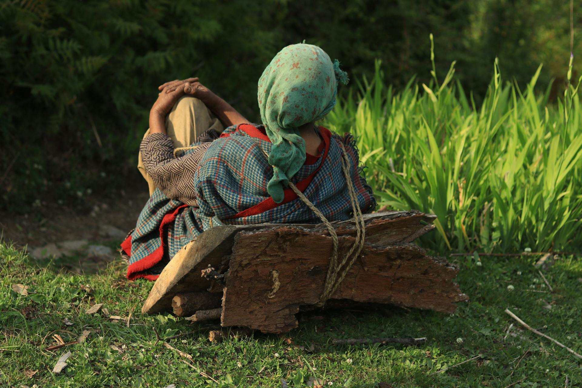 A Resting Person with Load of Woods on Her Back