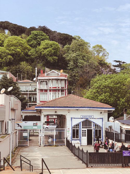 Free A quaint building in Sarıyer with lush green trees creating a serene background, perfect for urban travel enthusiasts. Stock Photo