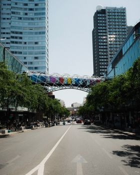 Dynamic view of a downtown street showcasing vibrant sky bridge and skyscrapers.