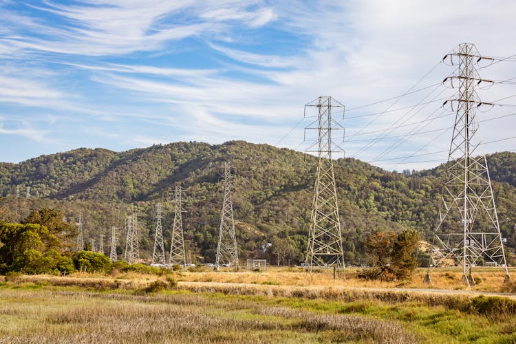 Electric Towers On Green Grass Field