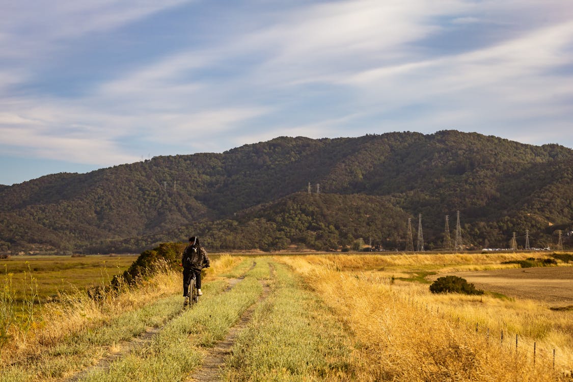 Free A Person Riding a Bike on a Dirt Road Stock Photo