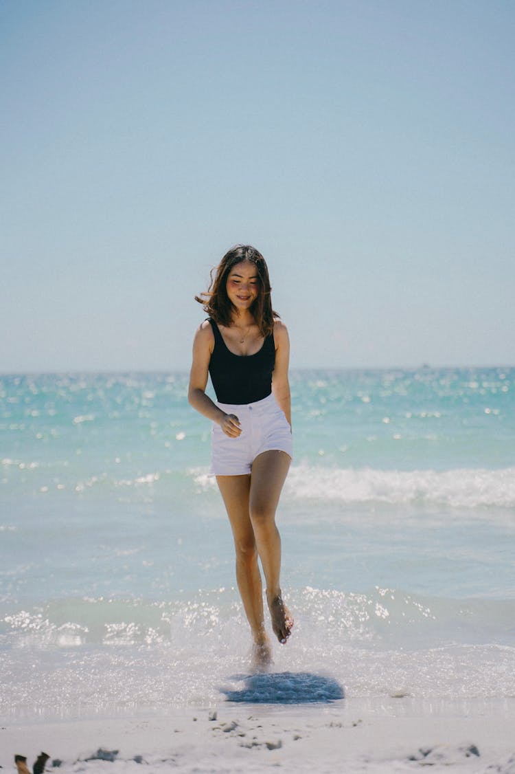 Happy Woman Running On Sand Beach