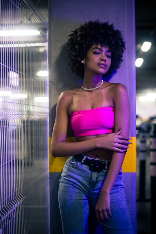 A Woman in Pink Tube Top Leaning on the Wall