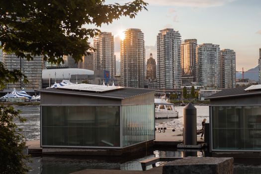 Vancouver cityscape with waterfront and skyscrapers during sunset, showcasing urban life in British Columbia.