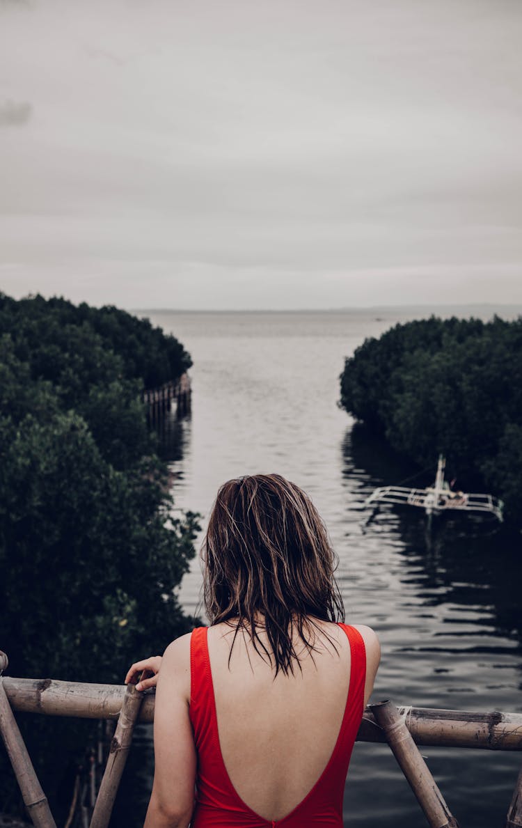 A Woman In Red Swimwear Standing On The View Deck