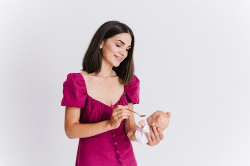 Young Woman Playing Feeding Baby Toy