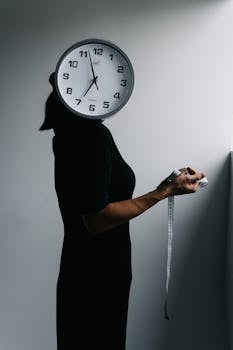 Artistic representation of time with a clock faced figure holding measuring tape.