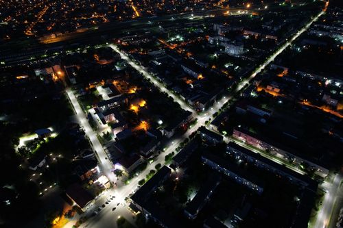 Free Drone capture of Kovel, Ukraine at night showcasing illuminated streets and buildings. Stock Photo