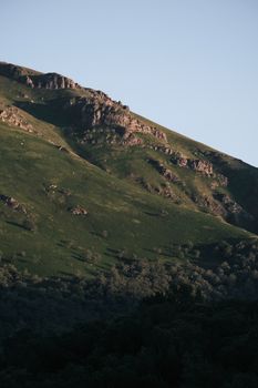 Breathtaking view of a lush green mountain slope under a clear blue sky.