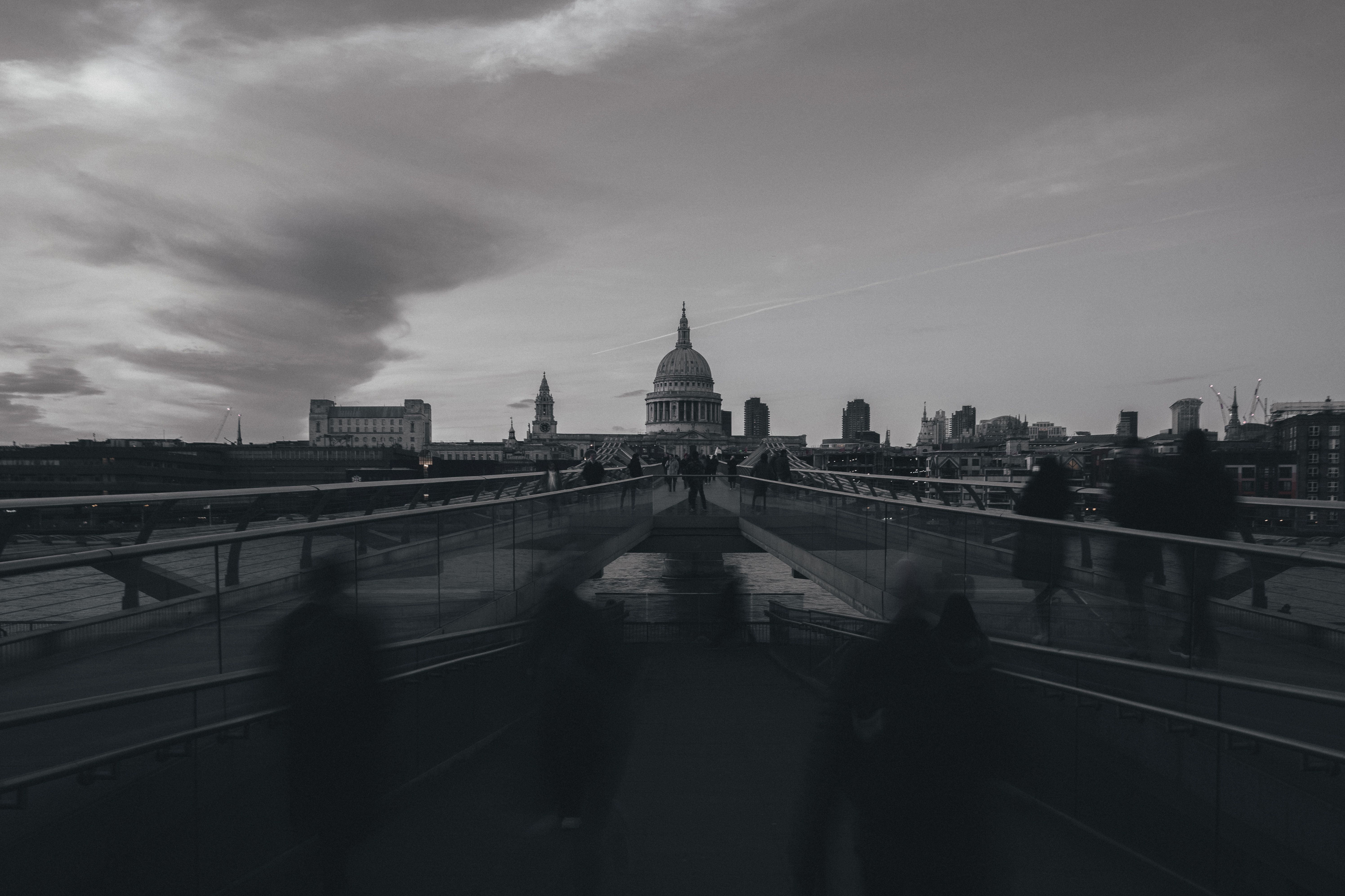A monochrome long exposure of Millennium Bridge leading to St. Paul's Cathedral in London.