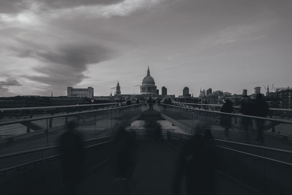 A monochrome long exposure of Millennium Bridge leading to St. Paul's Cathedral in London.