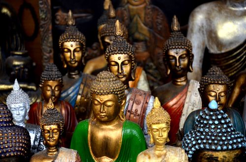 Free Ornate display of colorful Buddha statues in a Bali souvenir shop showcasing spiritual artistry. Stock Photo