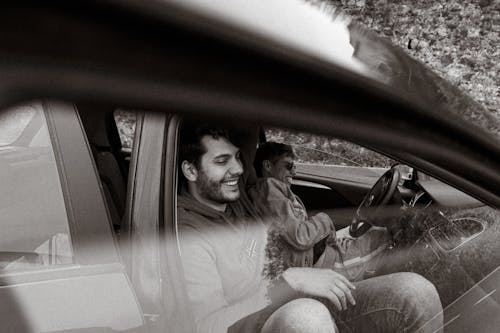 Free Men Sitting in a Car and Laughing  Stock Photo