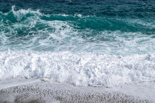 Free Vibrant ocean waves crashing on a sandy shore, capturing the beauty of nature's power and rhythm. Stock Photo