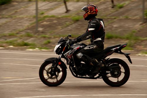 Free A motorcyclist in protective gear riding a sport bike on an urban street during the day. Stock Photo