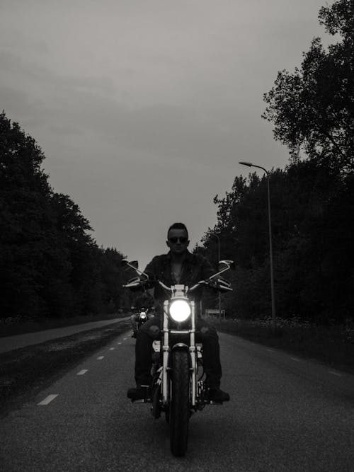 Grayscale Photo of Man Riding Motorcycle on the Road