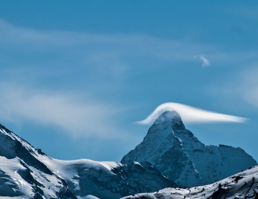 A stunning view of a snow-capped mountain peak under a clear blue sky.