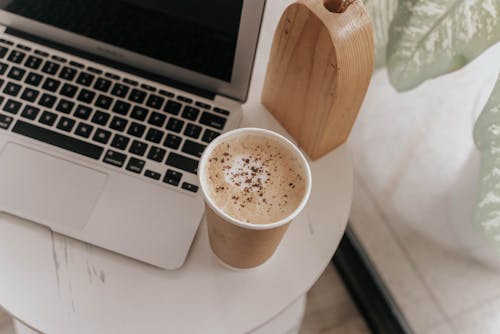 Close-Up Shot of a Cup of Coffee near a Laptop