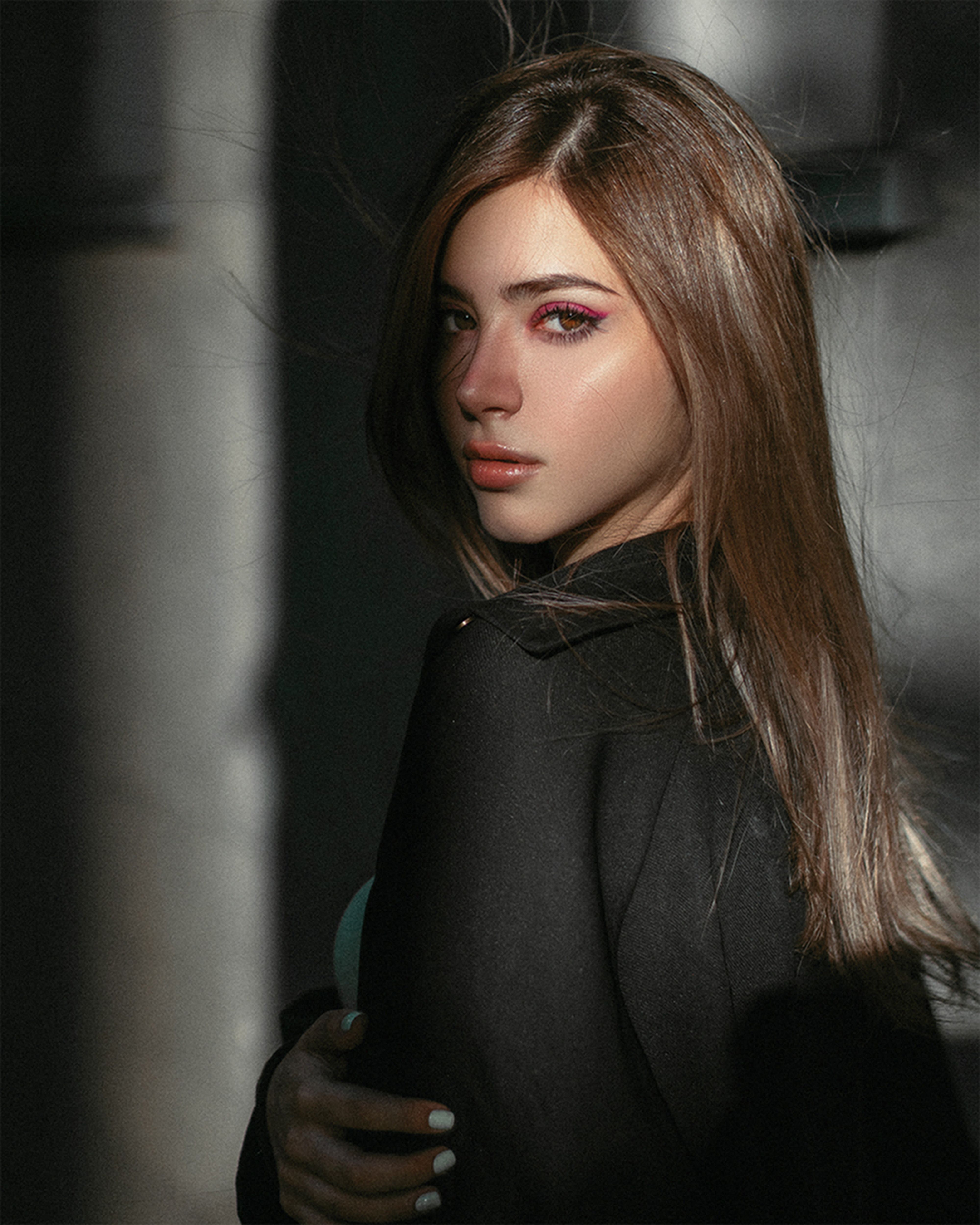 Close-up portrait of a woman with subtle lighting highlighting her features.