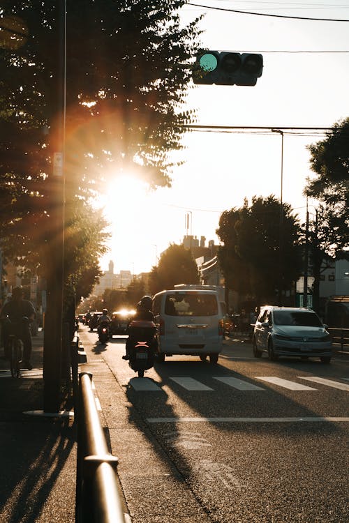 Vehicles Driving on Concrete Road during Sunset