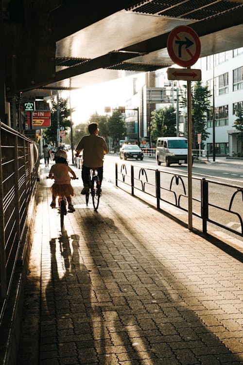 People riding Bicycle on a Side Walk 