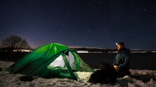 Free Man near Tent on Winter Camping in Fjords Stock Photo