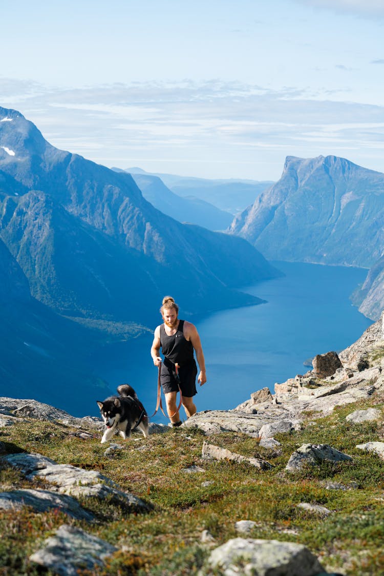 Man With Dog Hiking In Norway