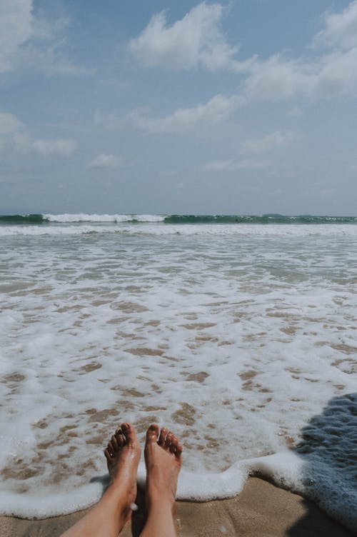 Free Person Sitting on Brown Seashore Stock Photo