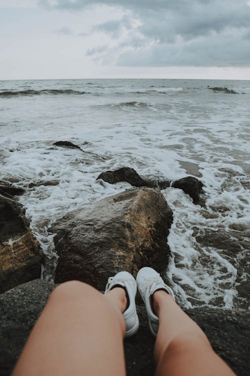 무료 바위에 앉아있는 사람 스톡 사진