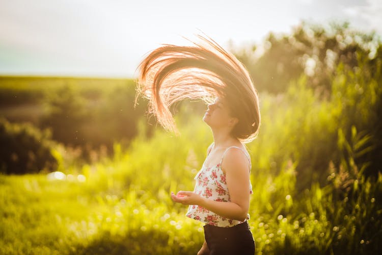 Close-Up Shot Of A Woman Doing Hair Flip During Sunset