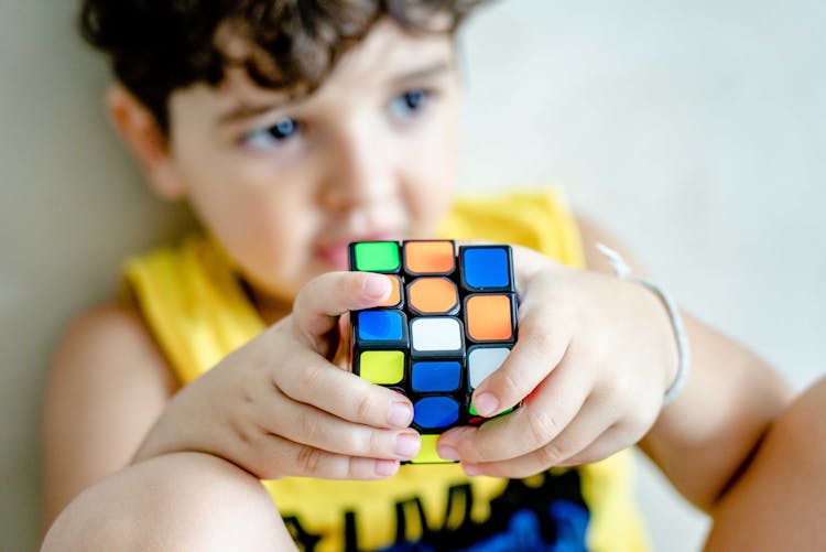 Close-Up Shot Of A Boy Holding A Rubiks Cube