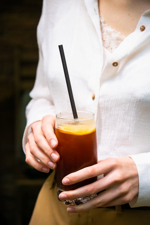 Woman Holding a Drink with a Straw