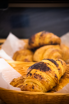 Delicious golden brown croissants perfectly baked served in a basket.