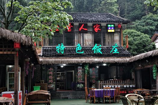 Traditional outdoor restaurant with thatched roof and Chinese lanterns.