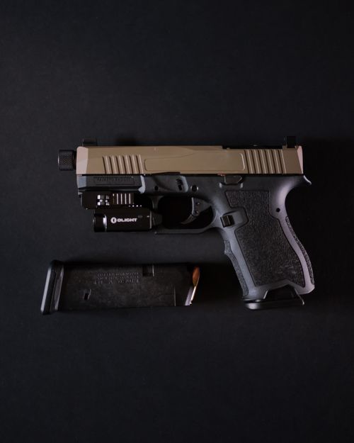 Free Detailed close-up of a handgun with magazine on a dark background emphasizing design and mechanics. Stock Photo