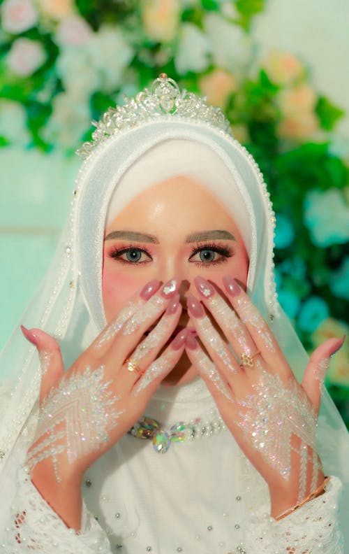 A Beautiful Bride in White Hijab while Covering Her Face Using Her Hands