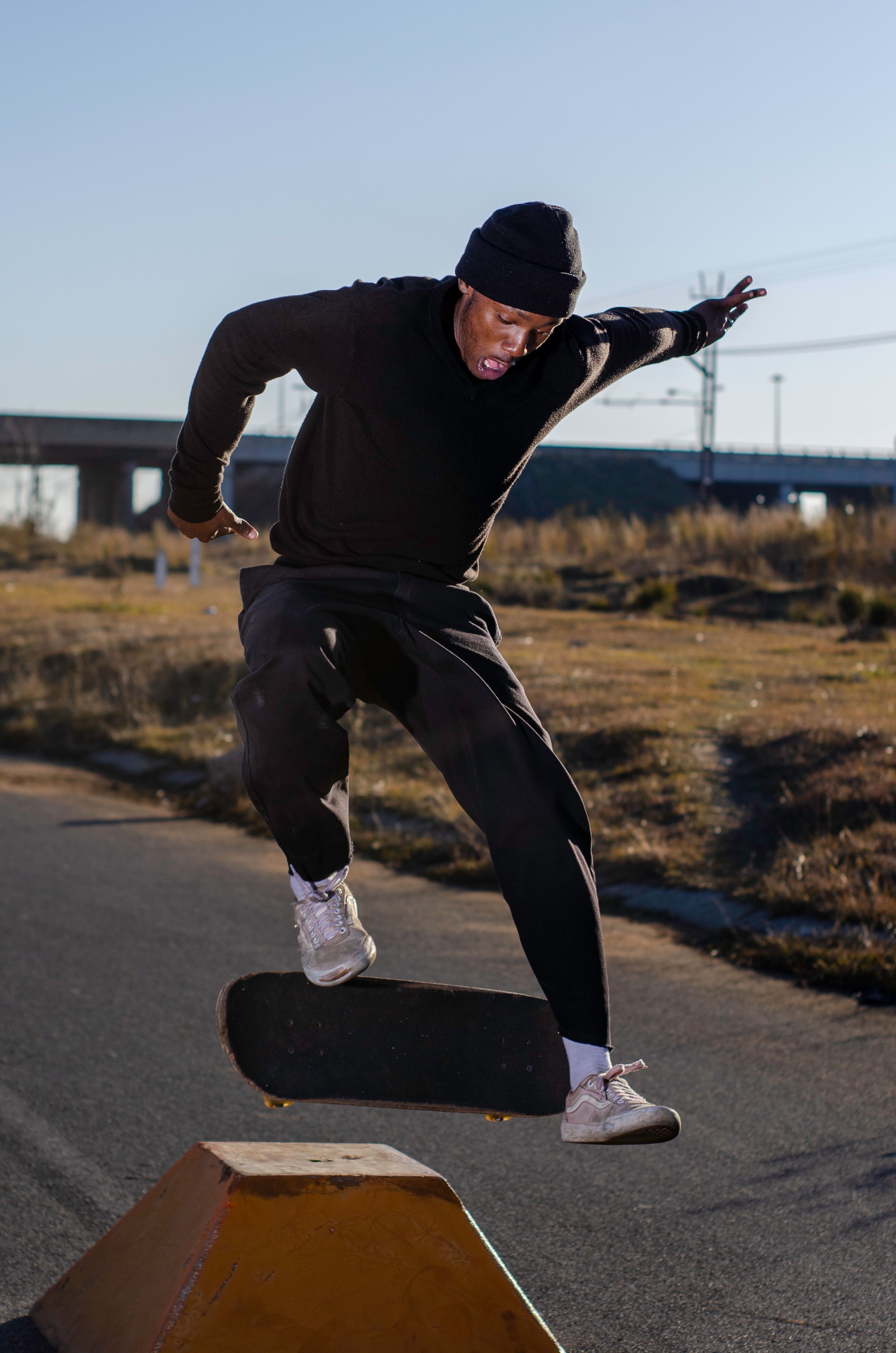 Skilled skater executing jump tricks outdoors in a skate park, captured in action.