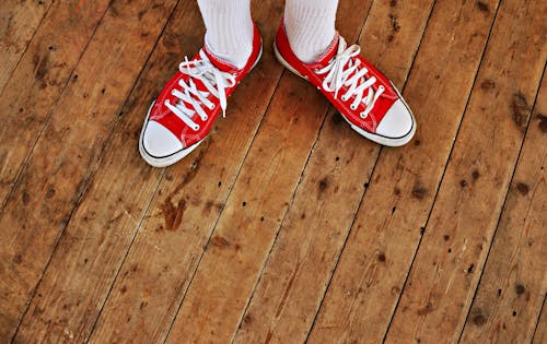 Free Person in Red Low Tops in Brown Wooden Floor Stock Photo