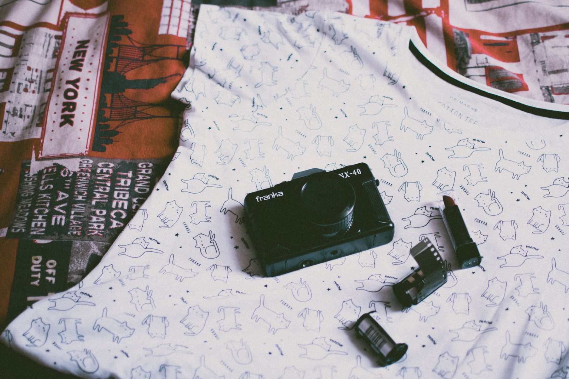 Vintage Franka VX-40 camera with film rolls on a graphic tee featuring New York prints.