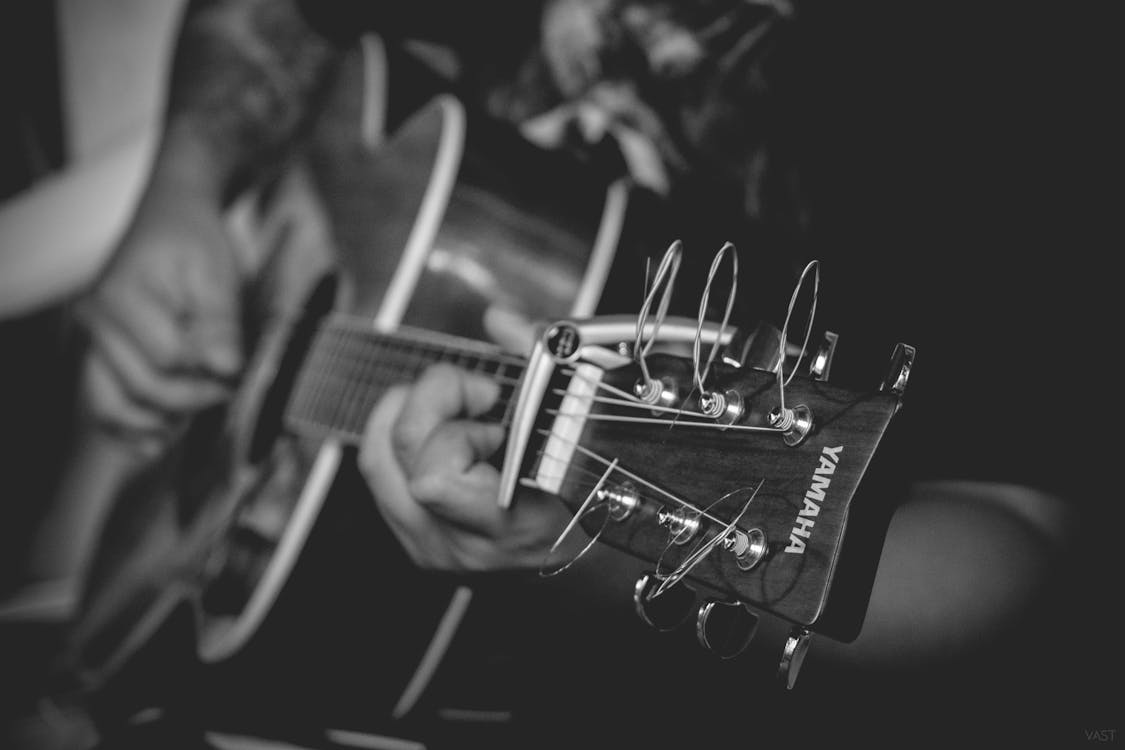 免费 演奏雅马哈民谣吉他的人的灰度摄影 素材图片