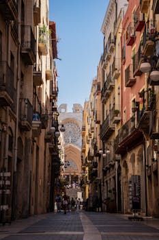 Scenic view of a narrow street in Tarragona, Spain, with historic architecture and bustling life.