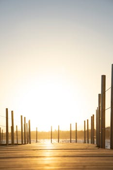 A serene sunset over the ocean from a wooden pier in Salou, Spain, capturing the tranquil beauty of the sea.