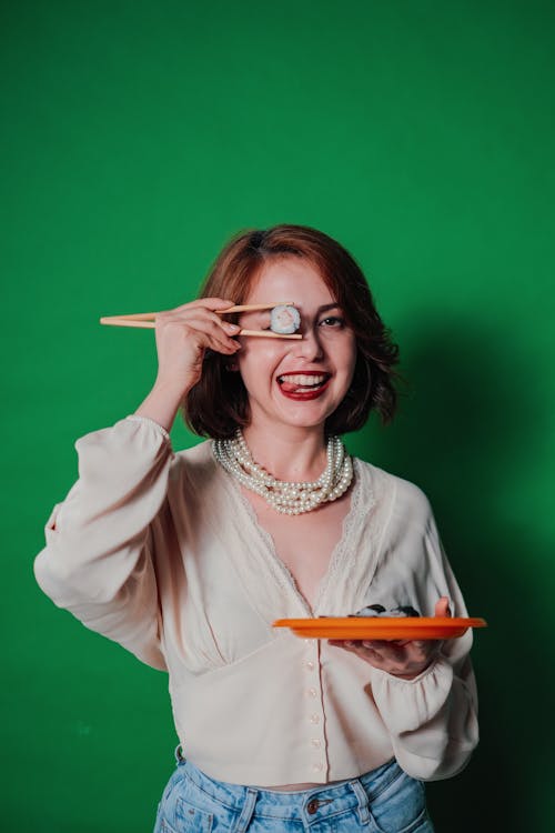 Woman Posing with Sushi on Green Background